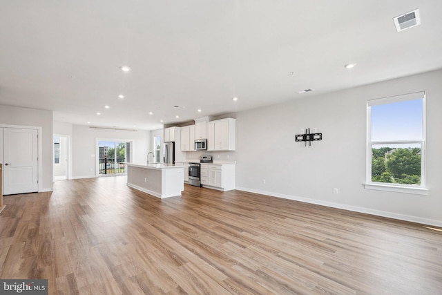 43730 Transit Sq, Ashburn, VA 20147 - unfurnished living room featuring recessed lighting, baseboards, light wood-type flooring, and a sink