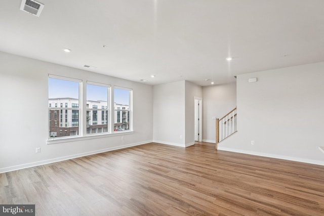 43730 Transit Sq, Ashburn, VA 20147 - unfurnished living room with wood finished floors, stairway, recessed lighting, and baseboards