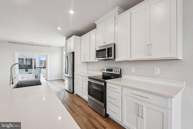 43730 Transit Sq, Ashburn, VA 20147 - kitchen with stainless steel appliances, a sink, dark wood finished floors, white cabinetry, and recessed lighting