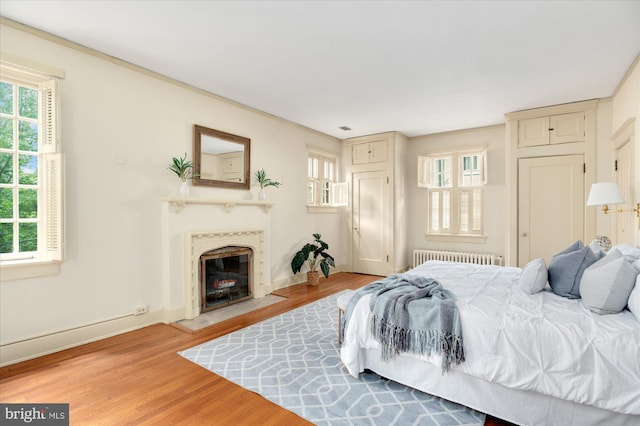 3419 Lowell St NW, Washington, DC 20016 - bedroom featuring radiator heating unit, multiple windows, and light wood-type flooring