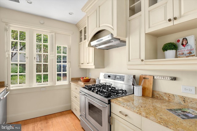 3419 Lowell St NW, Washington, DC 20016 - kitchen with double oven range, light wood-style flooring, glass insert cabinets, light stone countertops, and range hood