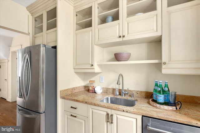 3419 Lowell St NW, Washington, DC 20016 - kitchen with stainless steel appliances, cream cabinetry, glass insert cabinets, and light stone countertops