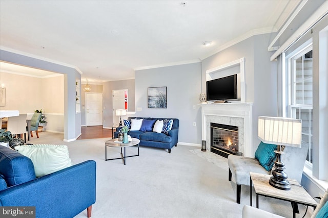 carpeted living room with a high end fireplace, baseboards, and ornamental molding