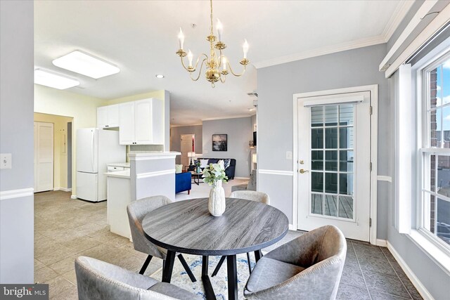 dining room with a chandelier, light tile patterned floors, ornamental molding, and baseboards