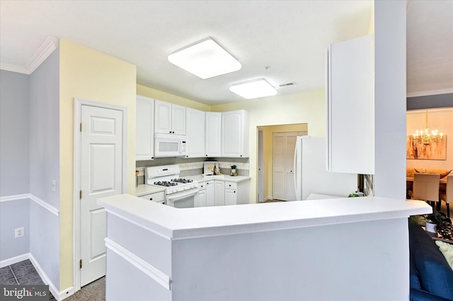 kitchen featuring white appliances, a chandelier, white cabinetry, baseboards, and ornamental molding
