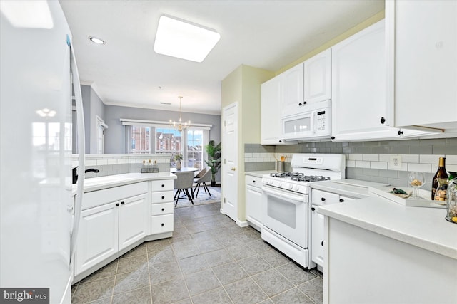kitchen featuring white appliances, a chandelier, backsplash, light countertops, and recessed lighting