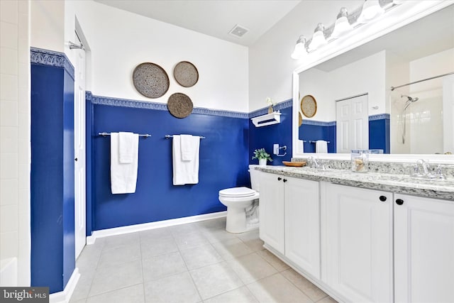 bathroom featuring tile patterned floors, a shower, toilet, double vanity, and baseboards