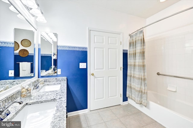 bathroom with tile patterned floors, shower / bathtub combination with curtain, double vanity, and baseboards