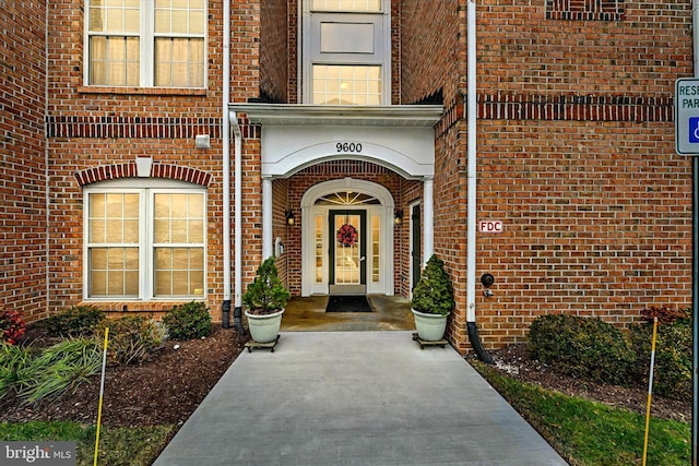 entrance to property featuring brick siding
