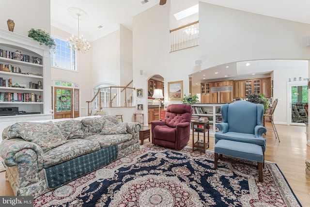11709 Pine Tree Dr, Fairfax, VA 22033 - living room featuring a towering ceiling, a chandelier, arched walkways, light wood finished floors, and stairway