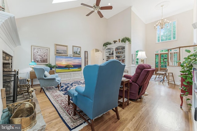 11709 Pine Tree Dr, Fairfax, VA 22033 - living room with high vaulted ceiling, a fireplace with raised hearth, ceiling fan, wood finished floors, and a chandelier