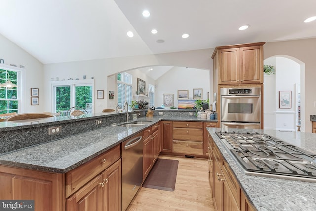 11709 Pine Tree Dr, Fairfax, VA 22033 - kitchen with appliances with stainless steel finishes, a sink, light wood-type flooring, arched walkways, and vaulted ceiling