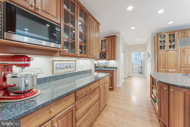11709 Pine Tree Dr, Fairfax, VA 22033 - kitchen featuring stainless steel microwave, light wood-type flooring, brown cabinets, recessed lighting, and dark stone countertops
