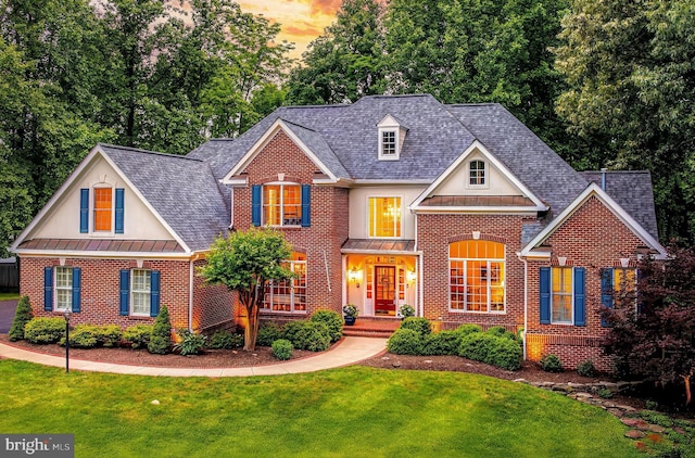11709 Pine Tree Dr, Fairfax, VA 22033 - view of front of property with brick siding, a standing seam roof, a yard, roof with shingles, and metal roof