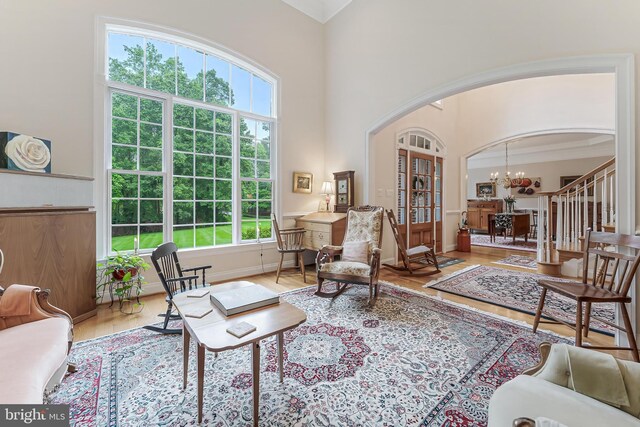11709 Pine Tree Dr, Fairfax, VA 22033 - living room featuring arched walkways, wood finished floors, a chandelier, stairs, and baseboards
