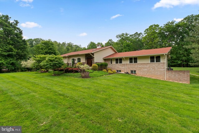 2312 Velvet Ridge Dr, Owings Mills, MD 21117 - view of front of home with a front lawn, a chimney, stucco siding, and brick siding