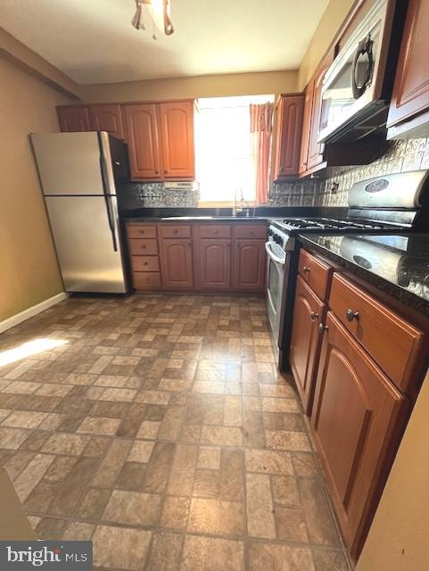 20 Galveston Pl SW Unit B, Washington, DC 20032 - kitchen with freestanding refrigerator, dark countertops, brick patterned flooring, gas range, and backsplash