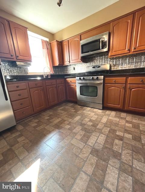 20 Galveston Pl SW Unit B, Washington, DC 20032 - kitchen with appliances with stainless steel finishes, dark countertops, backsplash, and brick patterned flooring