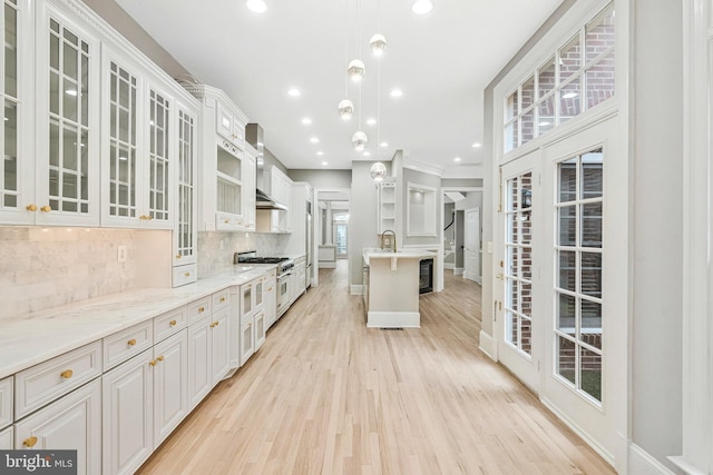 1473 Evans Farm Dr, Mclean, VA 22101 - kitchen with light wood finished floors, backsplash, range with two ovens, glass insert cabinets, and white cabinets