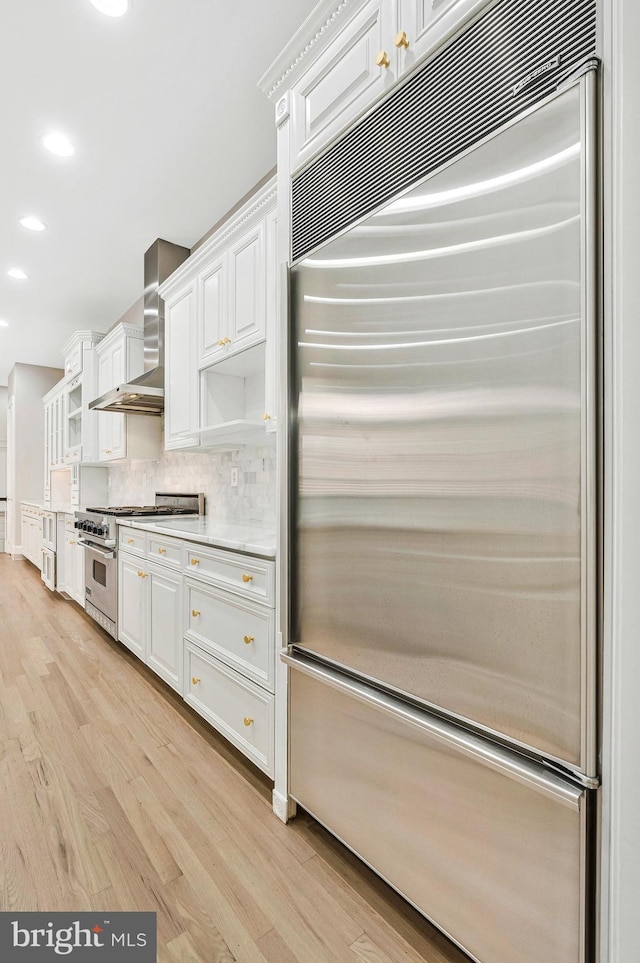 1473 Evans Farm Dr, Mclean, VA 22101 - kitchen featuring high end appliances, wall chimney exhaust hood, light wood-type flooring, white cabinetry, and recessed lighting