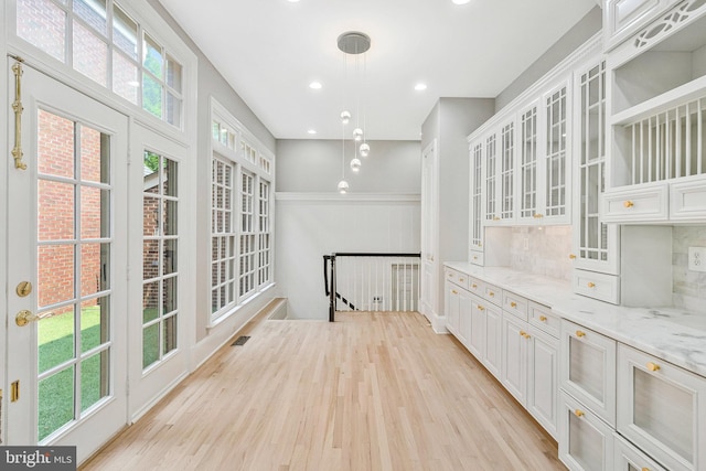 1473 Evans Farm Dr, Mclean, VA 22101 - kitchen featuring light wood-style flooring, white cabinets, light stone countertops, glass insert cabinets, and recessed lighting