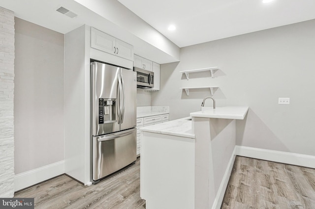 1473 Evans Farm Dr, Mclean, VA 22101 - kitchen featuring stainless steel appliances, open shelves, a peninsula, light wood-style flooring, and baseboards