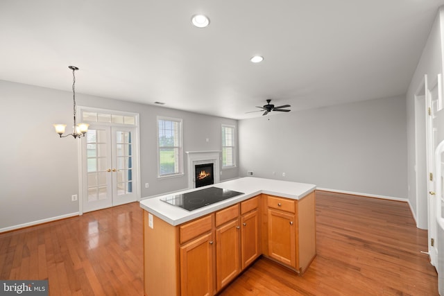 30 Amandas Teal Dr, Bridgeville, DE 19933 - kitchen with black electric cooktop, a warm lit fireplace, open floor plan, ceiling fan, and light countertops