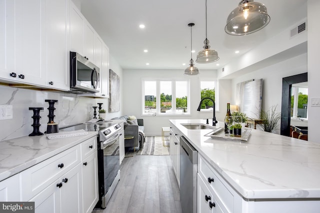 1732 Montello Ave NE Unit 7, Washington, DC 20002 - kitchen featuring appliances with stainless steel finishes, a sink, recessed lighting, light stone counters, and plenty of natural light