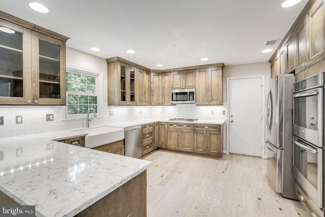5926 Clermont Landing Ct, Burke, VA 22015 - kitchen featuring stainless steel appliances, a sink, light stone counters, a peninsula, and recessed lighting