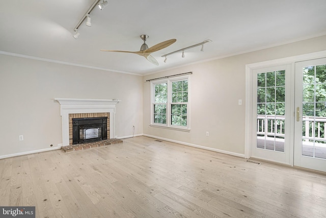 5926 Clermont Landing Ct, Burke, VA 22015 - unfurnished living room with track lighting, ceiling fan, crown molding, a brick fireplace, and plenty of natural light
