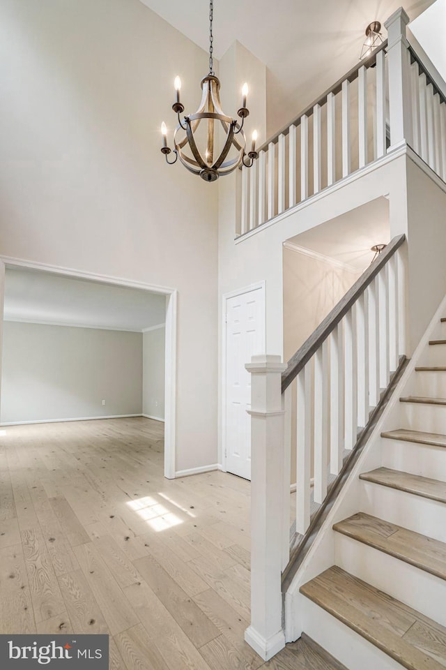 5926 Clermont Landing Ct, Burke, VA 22015 - staircase with high vaulted ceiling, a chandelier, wood-type flooring, and baseboards