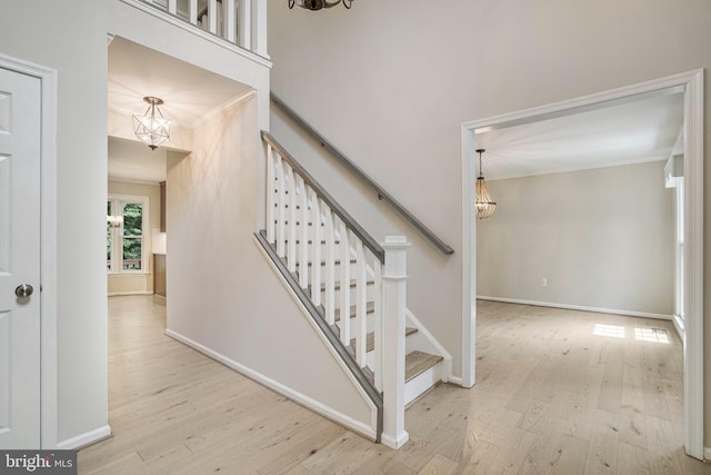 5926 Clermont Landing Ct, Burke, VA 22015 - staircase featuring a chandelier, ornamental molding, wood finished floors, and baseboards
