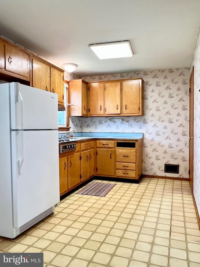 18 Jamaica Way, Hamilton, NJ 08610 - kitchen featuring freestanding refrigerator, wallpapered walls, light countertops, brown cabinets, and light floors