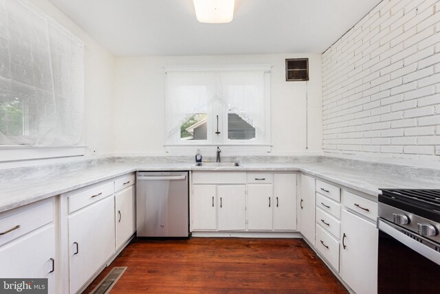 2806 Northumberland Hwy, Lottsburg, VA 22511 - kitchen with appliances with stainless steel finishes, a sink, dark wood finished floors, white cabinetry, and brick wall