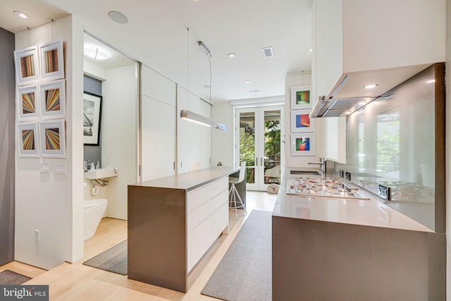 1448 Corcoran St NW, Washington, DC 20009 - kitchen featuring modern cabinets, white cabinetry, light wood-style flooring, french doors, and stainless steel gas cooktop