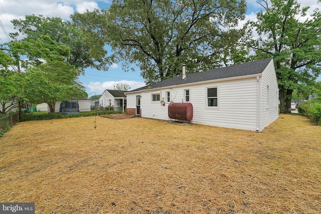 818 Dale Rd, Glen Burnie, MD 21060 - rear view of property featuring oil tank, fence, and roof with shingles