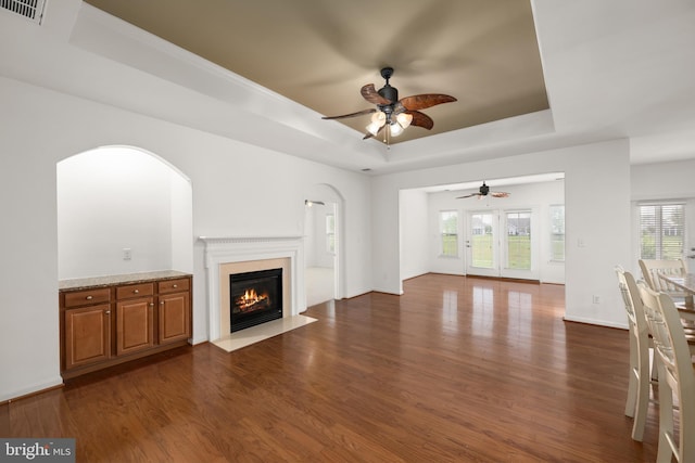 54 Ruddy Duck Ln, Bridgeville, DE 19933 - unfurnished living room featuring a raised ceiling, a ceiling fan, dark wood-style floors, a fireplace with flush hearth, and baseboards