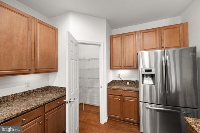 54 Ruddy Duck Ln, Bridgeville, DE 19933 - kitchen with stainless steel refrigerator with ice dispenser, dark wood-style floors, dark stone countertops, and brown cabinetry