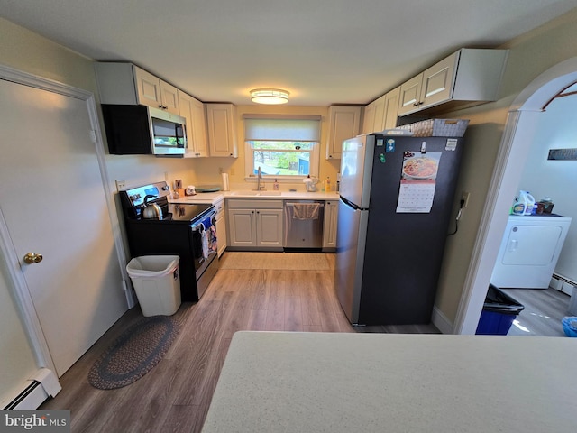 4113 Jacksonville Rd, Crisfield, MD 21817 - kitchen with stainless steel appliances, light wood-style flooring, light countertops, a sink, and baseboard heating