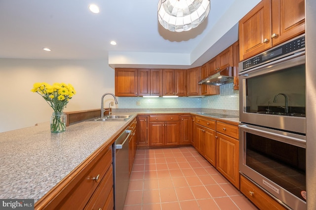 27 Manchester Ct Unit 27, Berwyn, PA 19312 - kitchen featuring a sink, stainless steel appliances, light tile patterned floors, under cabinet range hood, and brown cabinets