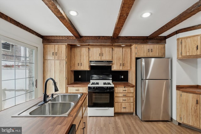 1142 Tree St, Philadelphia, PA 19148 - kitchen featuring freestanding refrigerator, gas range oven, a sink, under cabinet range hood, and beamed ceiling