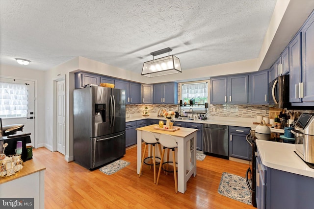 308 Fawn Dr, Winchester, VA 22602 - kitchen with stainless steel appliances, light countertops, tasteful backsplash, a textured ceiling, and light wood-style flooring
