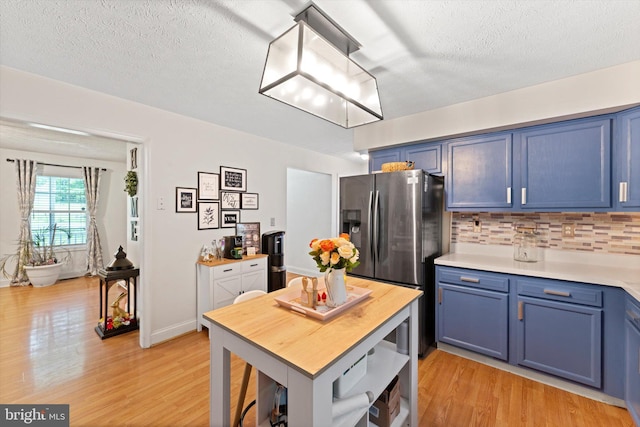 308 Fawn Dr, Winchester, VA 22602 - kitchen with blue cabinetry, stainless steel fridge, light wood finished floors, light countertops, and a textured ceiling