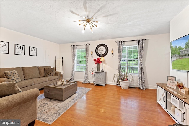 308 Fawn Dr, Winchester, VA 22602 - living area featuring light wood-type flooring, a textured ceiling, a chandelier, and baseboards