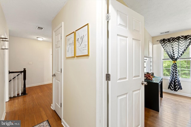 308 Fawn Dr, Winchester, VA 22602 - hallway featuring an upstairs landing, wood-type flooring, a textured ceiling, and baseboards