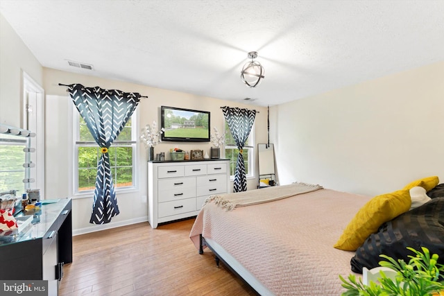 308 Fawn Dr, Winchester, VA 22602 - bedroom with light wood-style floors, a textured ceiling, and baseboards