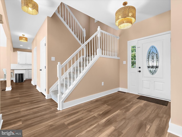 7827 Catherine Ave, Pasadena, MD 21122 - entrance foyer featuring stairway, dark wood-style flooring, and a chandelier