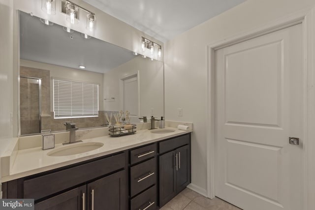 bathroom with tile patterned floors, double vanity, and tiled shower
