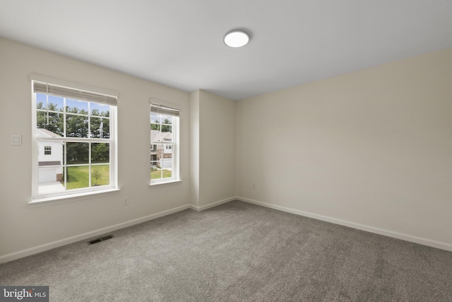 empty room featuring carpet flooring and baseboards