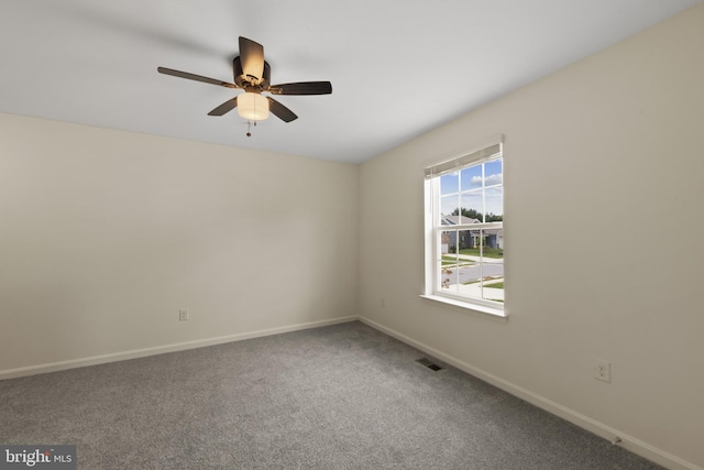 carpeted empty room with baseboards and a ceiling fan